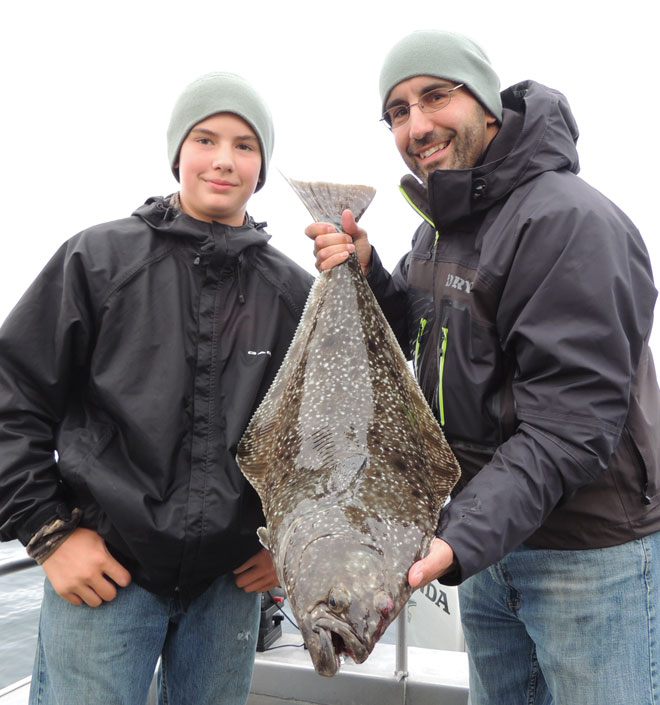 Travis Huisman and son Tanner admire Travis' first halibut.